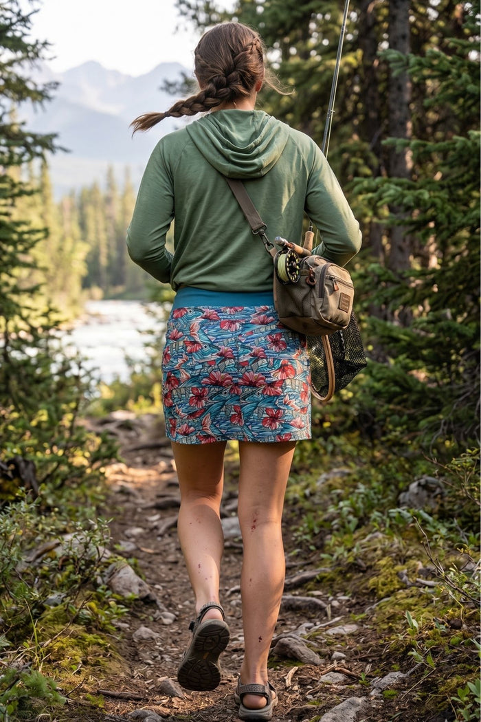 Person hiking on a trail with mountains and trees in the background