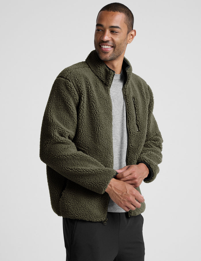 model wearing a men's green fleece zip-up jacket on a light gray background.