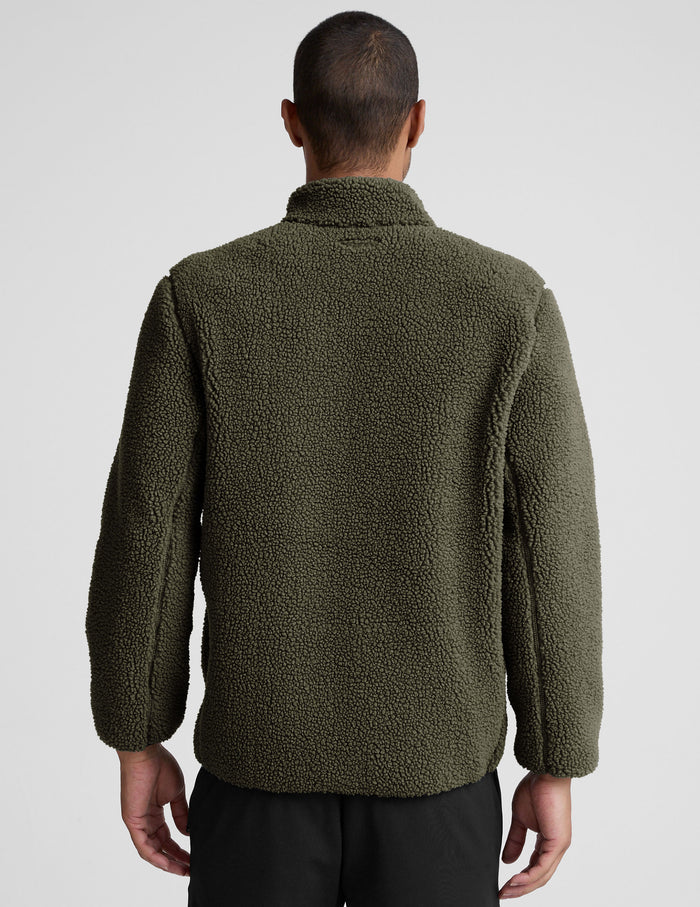 model wearing a men's green fleece zip-up jacket on a light gray background.