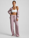 Pink corduroy lounge pants worn by a person on a light gray background.