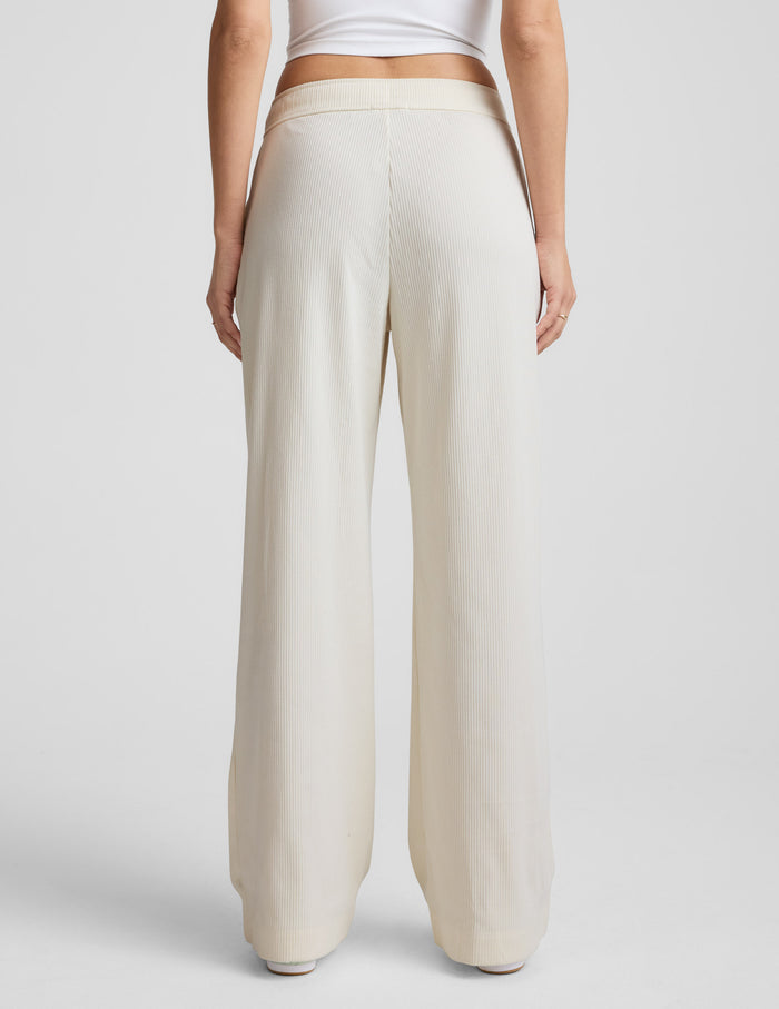 Rear view of a person wearing the cream Breathe Easy Comfort Cord Pant, featuring a wide-leg fit and ribbed corduroy fabric.
