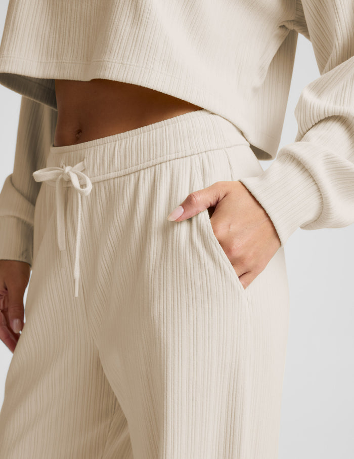 Cream Breathe Easy Ribbed Wide Leg Pant featuring a ribbed texture, elastic drawstring waist, and side slant pockets.