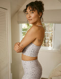 Woman wearing a neutral mini moon printed athletic outfit standing indoors.