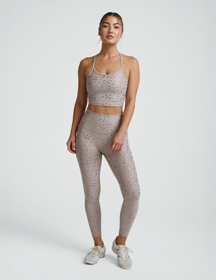 woman in pink mini moon printed cropped tank and leggings against a plain background.