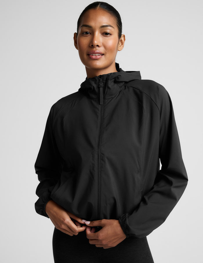 Person wearing a black jacket on a light gray background.