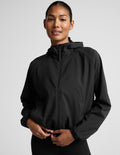 Person wearing a black jacket on a light gray background.