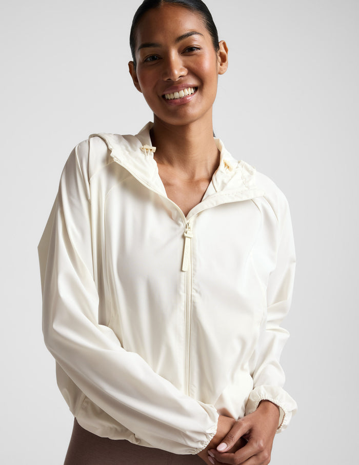 Woman wearing a white jacket against a plain background.