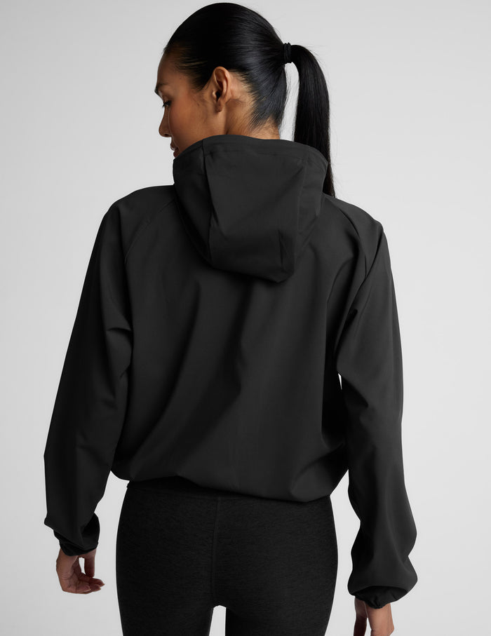 Person wearing a black jacket on a light gray background.
