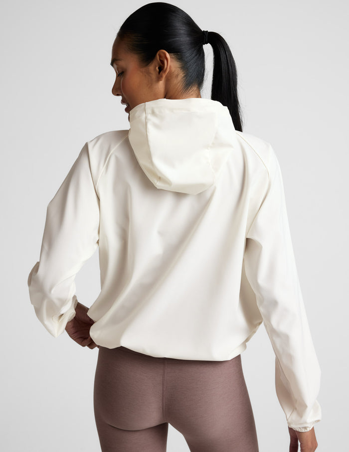 Woman wearing a white jacket against a plain background.