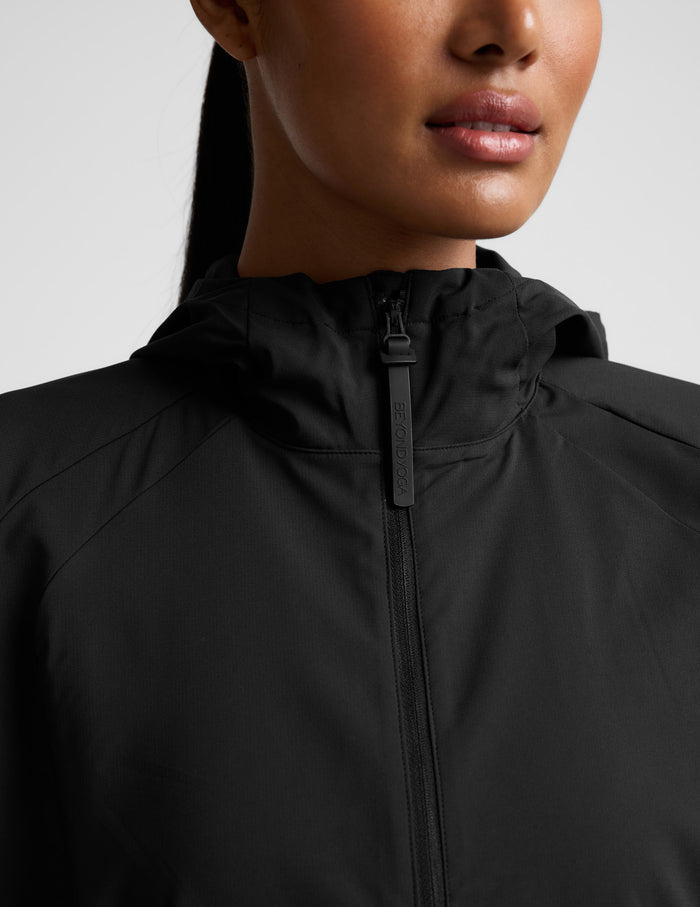 Person wearing a black jacket on a light gray background.