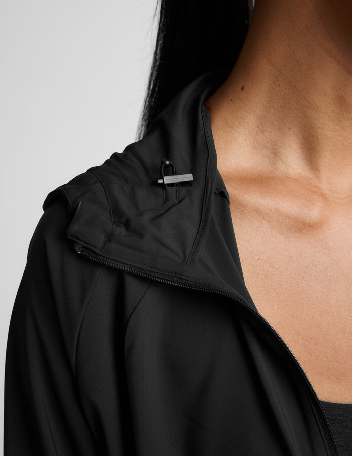 Person wearing a black jacket on a light gray background.