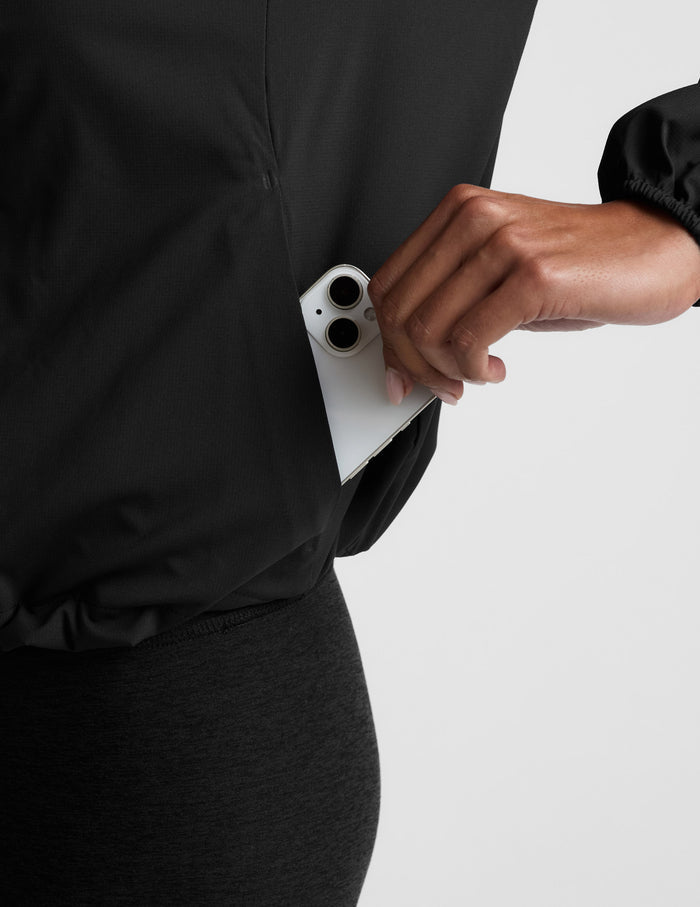 Person wearing a black jacket on a light gray background.