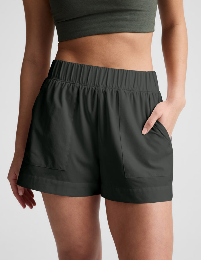 Model wearing the dark gray Easy 3" Short featuring a gathered elastic waistband and front side seam pockets.