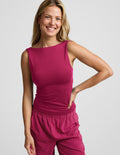 Woman wearing a red tank top and red pants against a plain background.