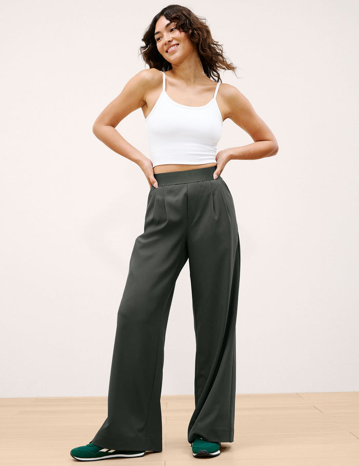 Woman posing in dark green wide-leg Elasticated Trouser Pant 29" with a pleated front and stretchy elastic waistband.