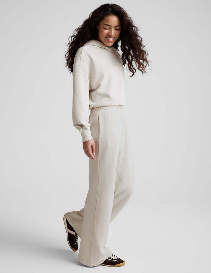 Woman wearing Cream Fade Out™ Mid-Rise Sweatpant in side profile, paired with a matching cream hoodie and sneakers.