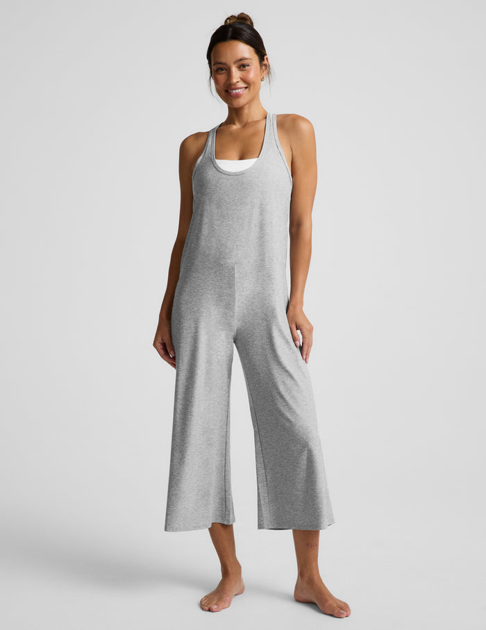 Woman wearing a gray jumpsuit on a white background.
