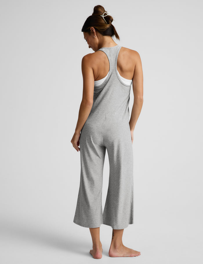Woman wearing a gray jumpsuit on a white background.