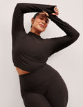 model wearing a brown mock neck cropped long sleeve against a plain background.