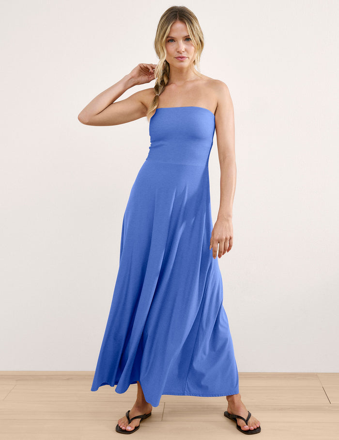 Woman wearing a blue strapless maxi dress against a light gray background.