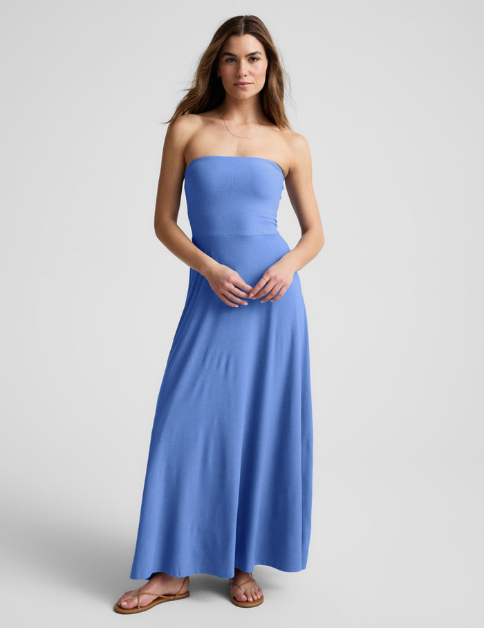 Woman wearing a blue strapless maxi dress against a light gray background.