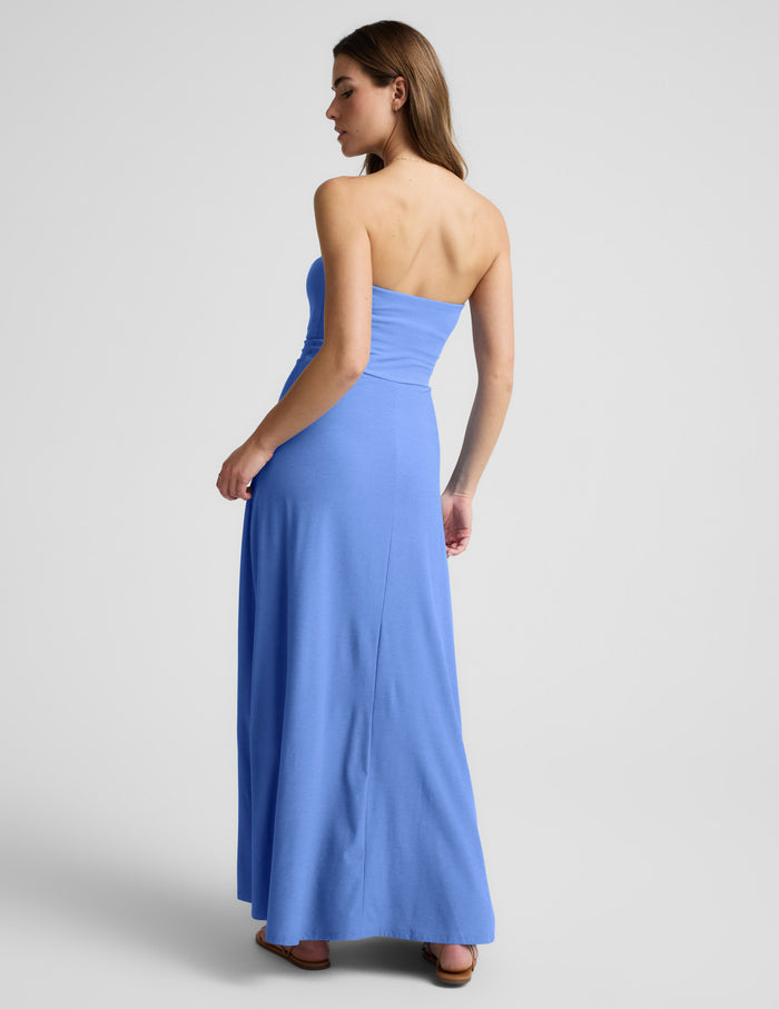 Woman wearing a blue strapless maxi dress against a light gray background.