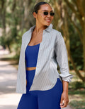 Woman wearing a blue striped poplin long sleeve shirt and a matching royal blue athletic set.