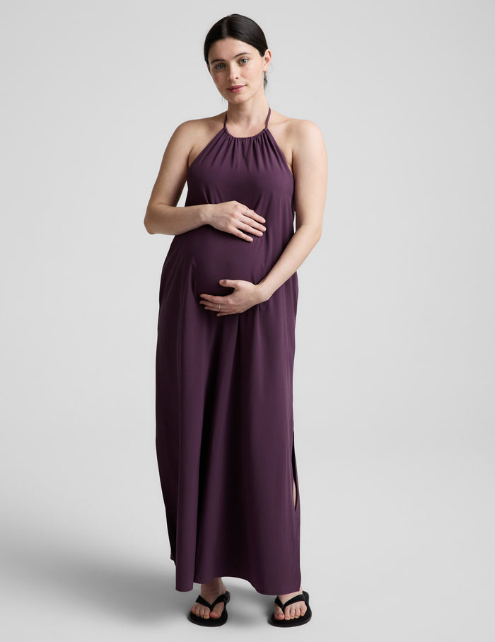 Woman wearing a purple dress against a plain background.