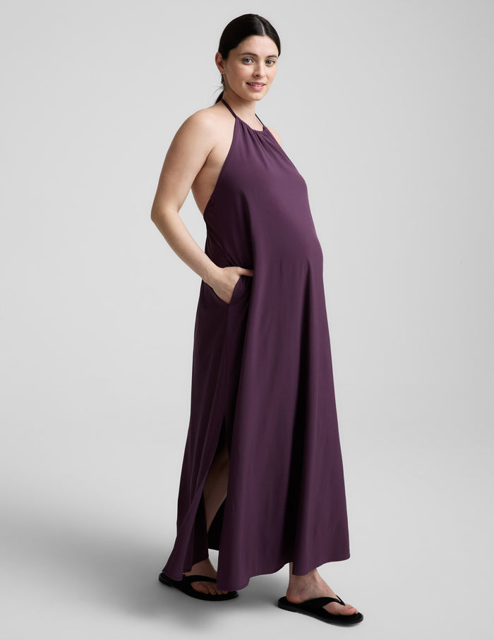 Woman wearing a purple dress against a plain background.