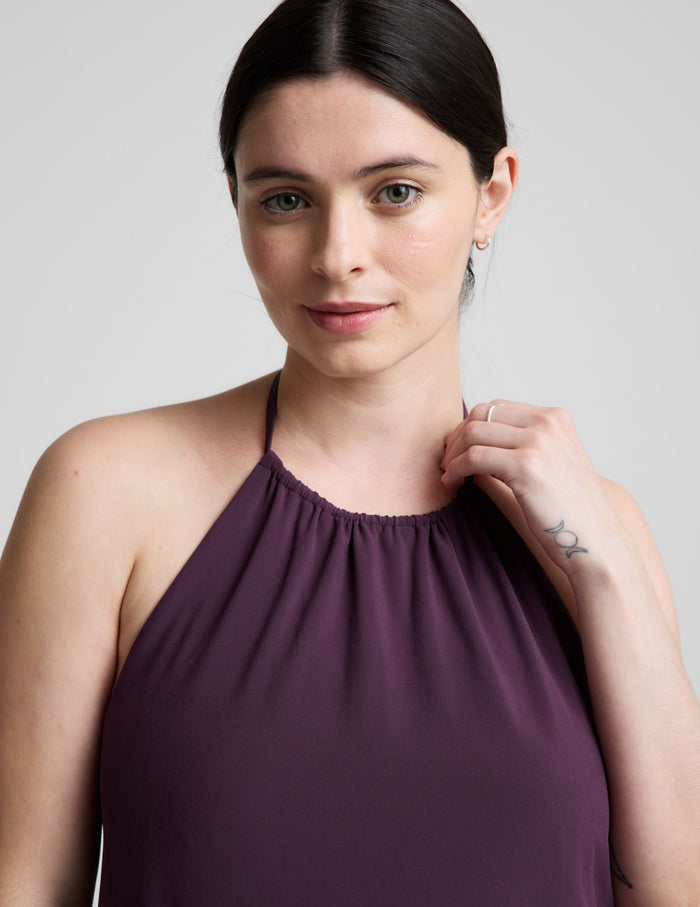 Woman wearing a purple dress against a plain background.
