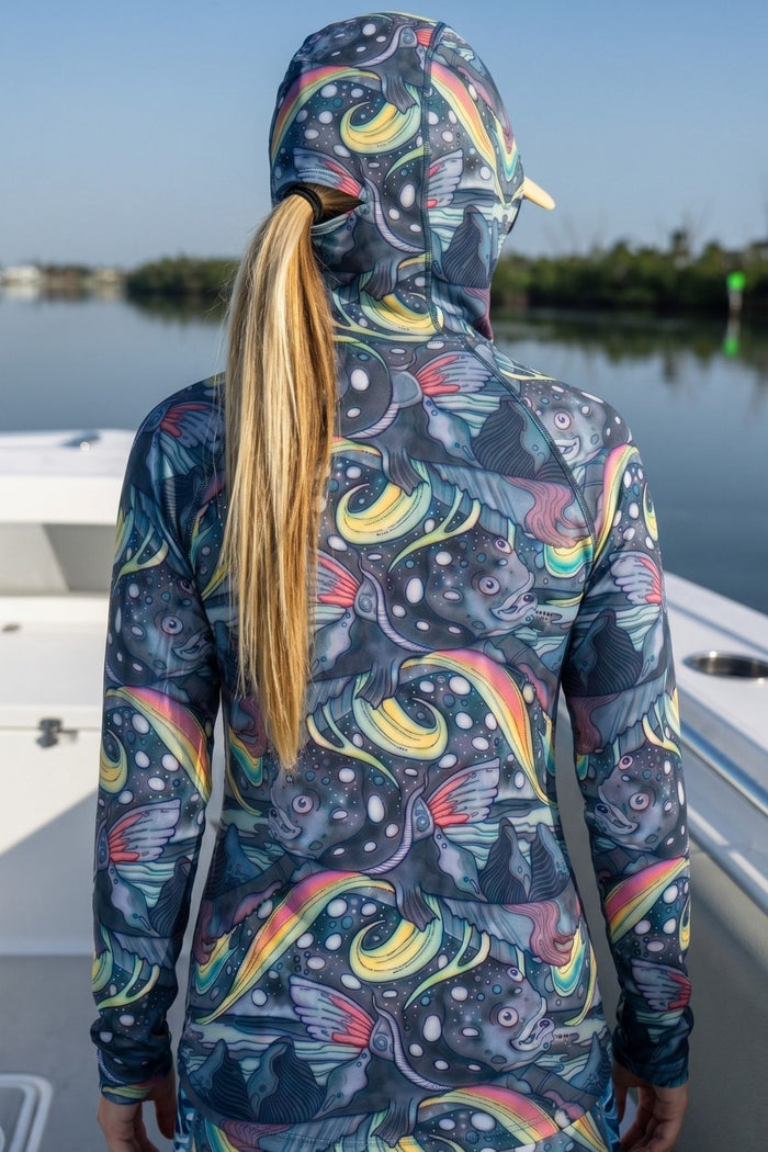Person wearing a colorful hooded jacket with a pattern on a boat