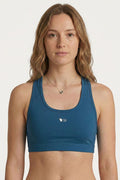 Woman wearing a blue sports bra with a logo on a white background