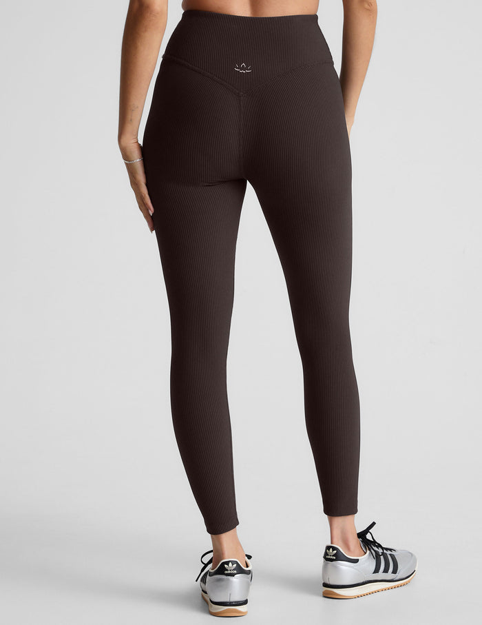 model wearing brown ribbed high-waisted midi length leggings against a plain background.