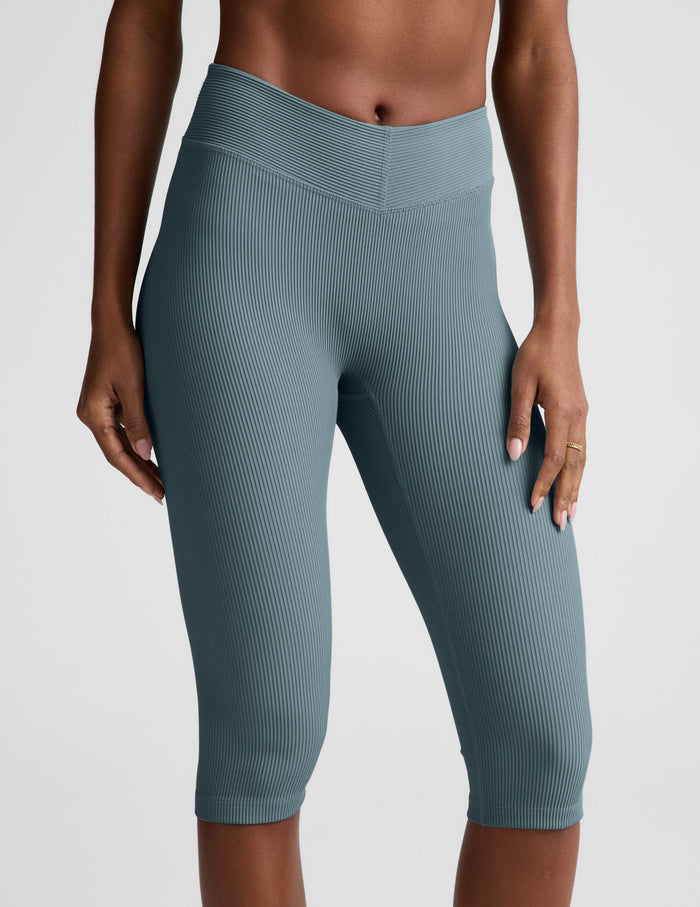 Woman wearing Slate blue Impulse™ Ribbed V-Waist Pedal Pusher Legging with a bare midriff.