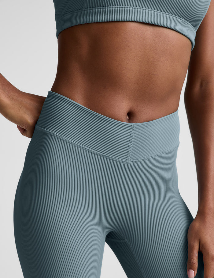 Woman wearing Teal Impulse Ribbed V-Waist Pedal Pusher Legging™ with a matching ribbed sports bra.