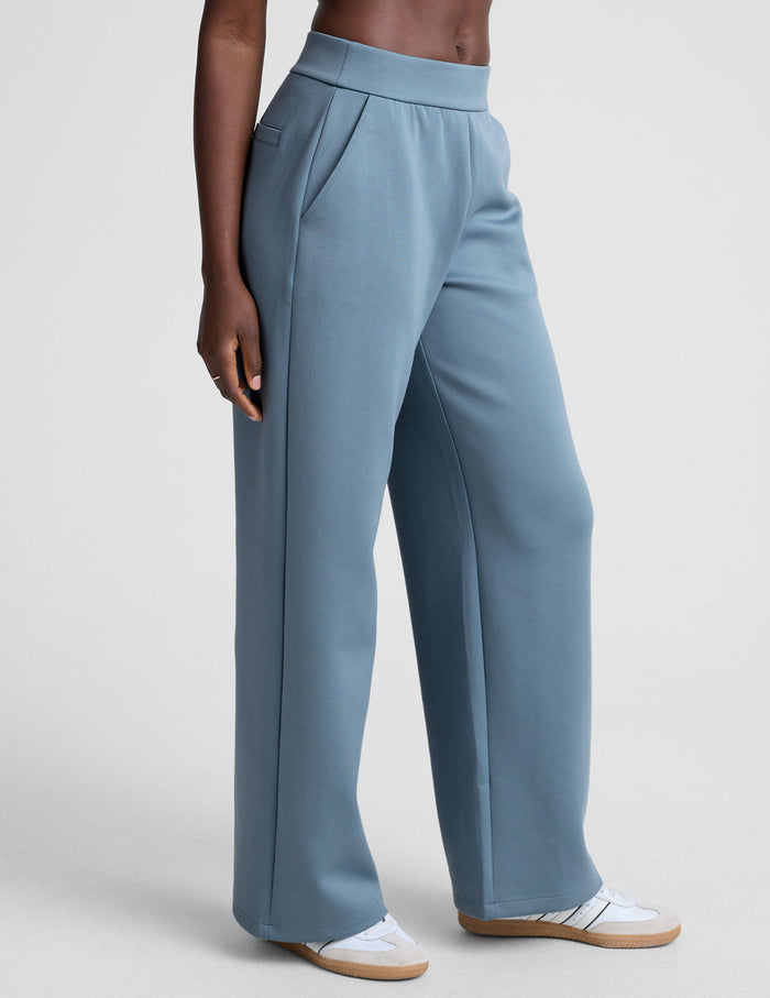 In The Flow Wide Leg Pant in dusty blue on a model, with high elastic waistband, slant pockets, and a loose, full-length fit.