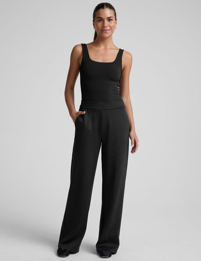 Model wearing the black In The Flow Wide Leg Pant with a wide-leg silhouette, elastic waistband, and side slant pockets.