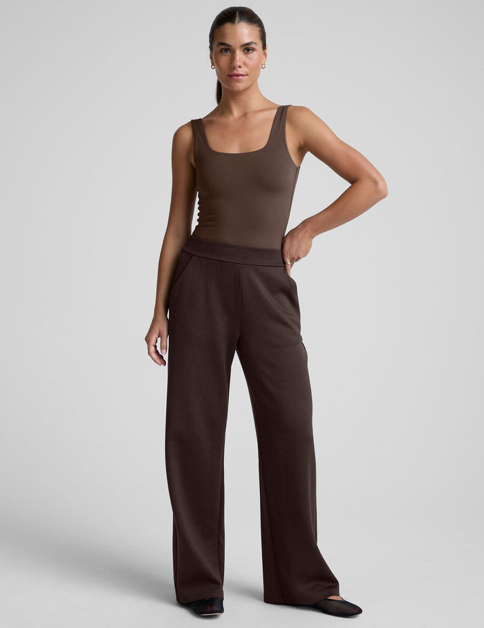 Full-length view of the In The Flow Wide Leg Pant in dark brown with an elastic waist and front pockets on a model.