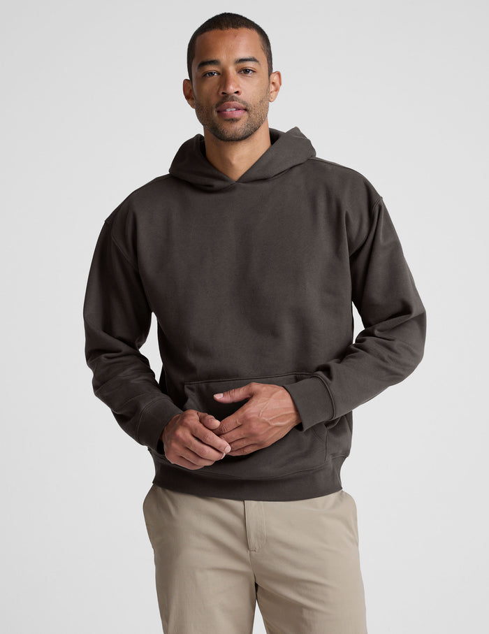 Man wearing a dark brown hoodie on a light gray background | mens