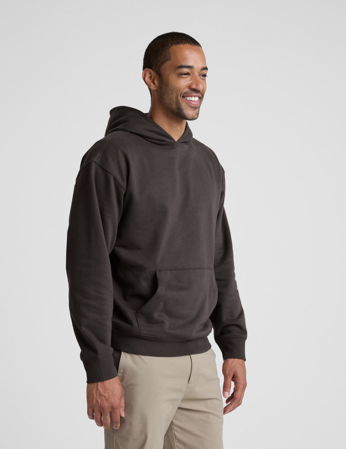 Man wearing a dark brown hoodie on a light gray background | mens