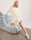 white sweat shorts with pockets and a drawstring at waistband.