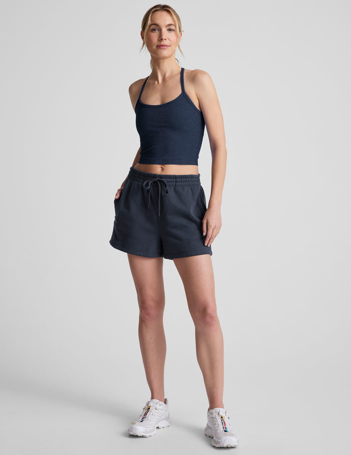 Navy LuxeFleece Sweat Short on a model, featuring a relaxed mid-rise fit, elastic drawstring waist, and side seam pockets.