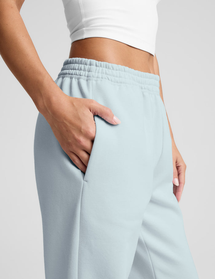 Close-up side view of light blue LuxeFleece Sweatpant with a gathered elastic waistband and hand in the side seam pocket.