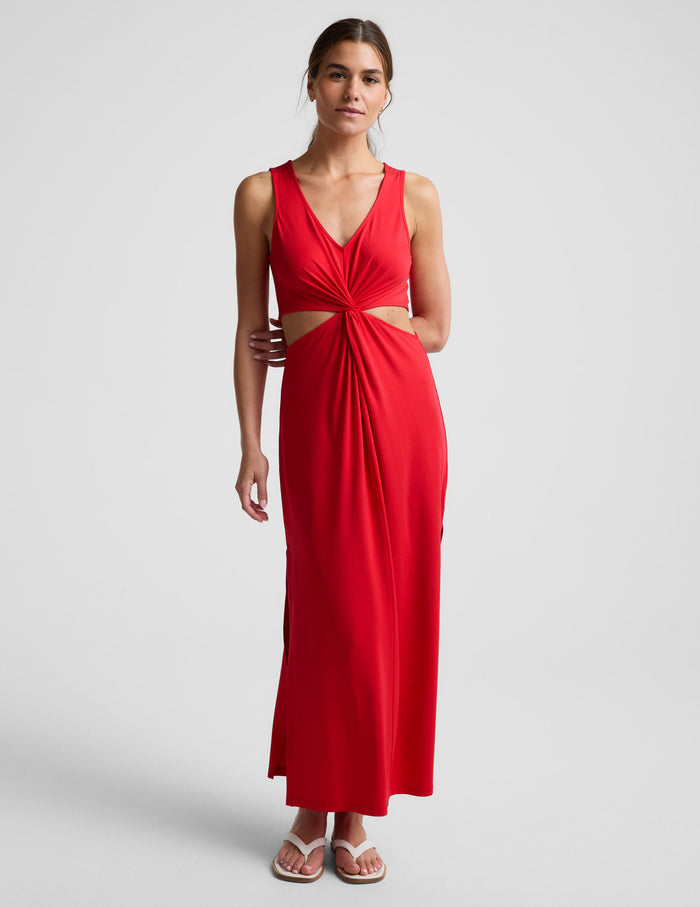 Woman wearing a red dress with cut-out design on a white background.
