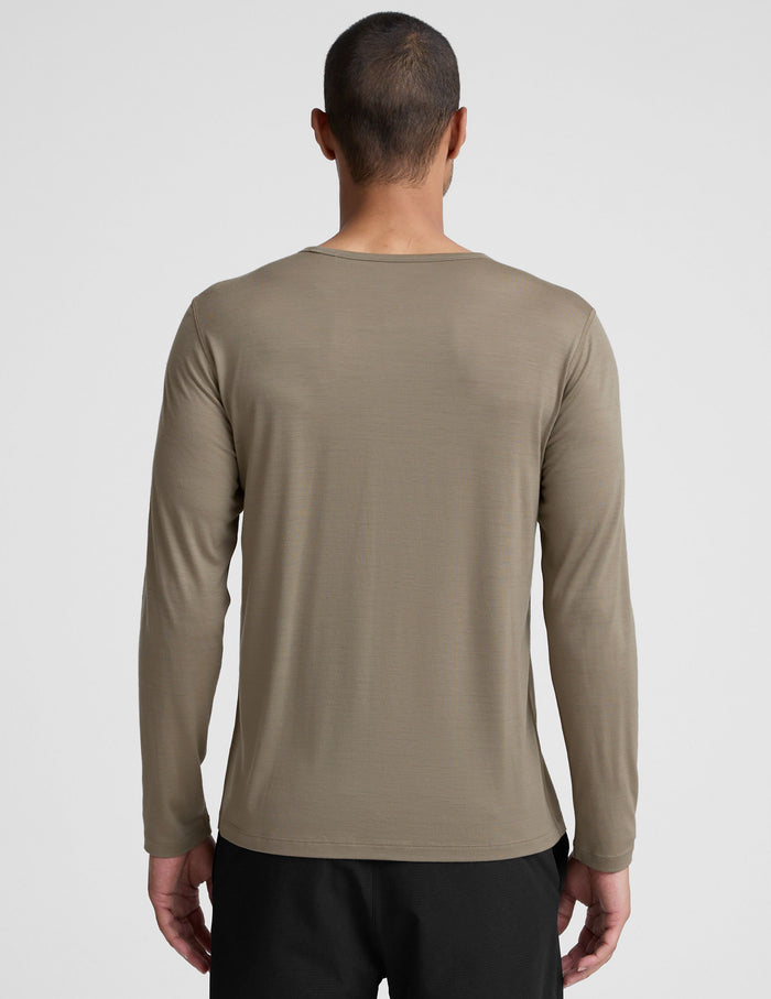 Man wearing a brown long-sleeve shirt against a plain background.