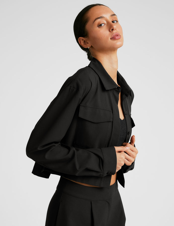 black cropped loose fitting jacket with a collar at neckline​, hidden placket with button closure at center front​, and front chest cargo pockets.