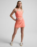 Woman wearing Coral Midweight Spacedye Overlap Skirt™ with a matching tank, featuring a front waist twist and wrap front.