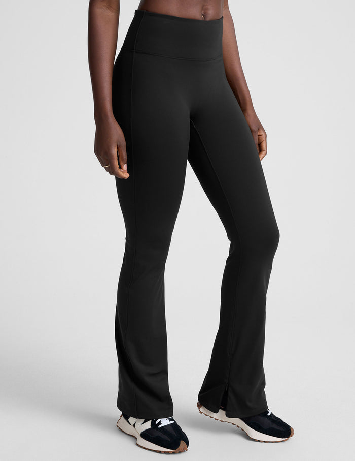 Model wearing black Pacer Fleece Pant featuring a high-waisted, snug-fit bootcut silhouette with ankle zipper details.