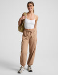 Woman wearing Java Peak Pant™ with a white tank top, featuring an elastic drawstring waist and side patch cargo pockets.