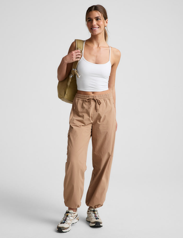 Woman wearing Java Peak Pant™ with a white tank top, featuring an elastic drawstring waist and side patch cargo pockets.